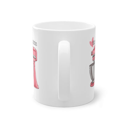 a white coffee mug with a pink handle